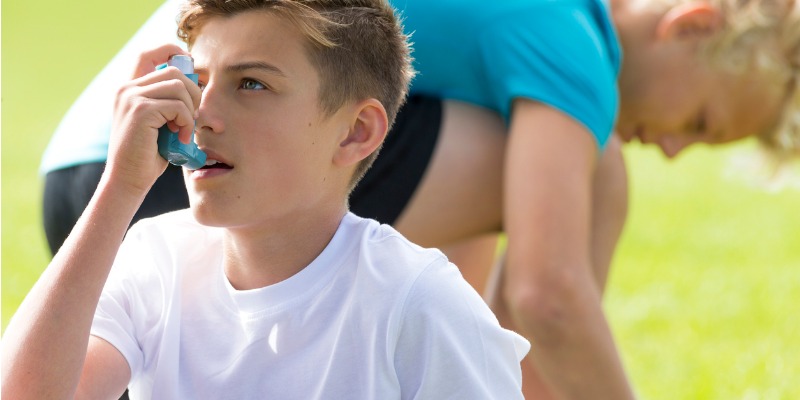 male student with asthma inhaler participating in sport