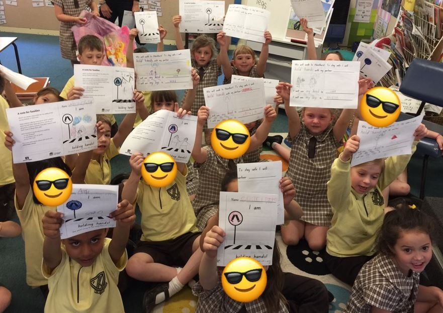 Students holding up their completed activity sheets.