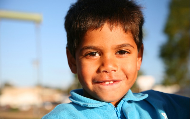 Young Aboriginal boy outside with the sun on his face
