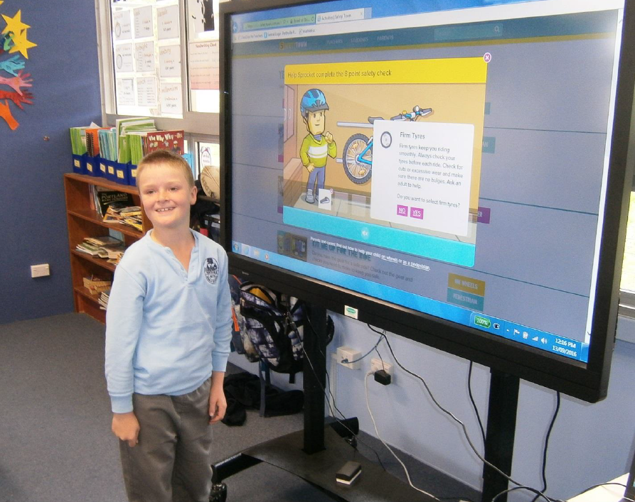 Smiling student in front of interactive whiteboard.