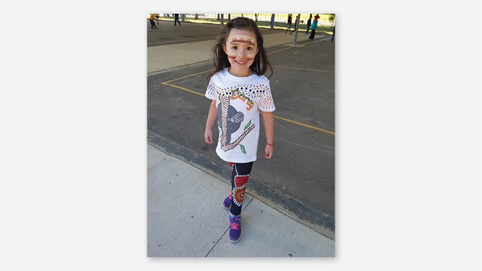 Batemans bay public school student in face paint and wearing clothes decorated with Aboriginal art.