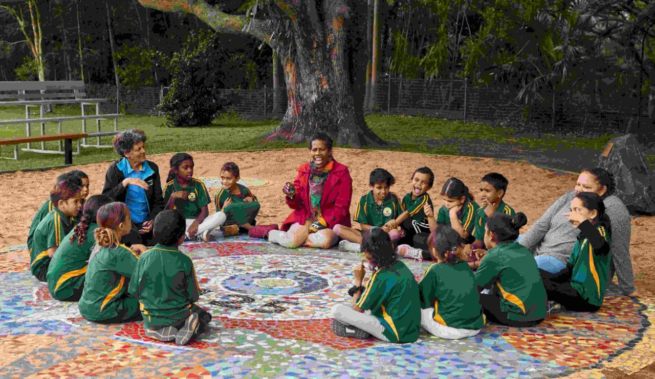 image of indigenous gathering with community elder and students around a circle
