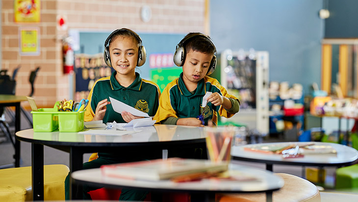 Two students at a desk in the classroom working together.