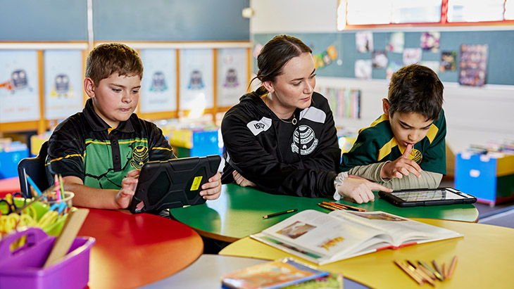 Students working in the classroom with the teacher.