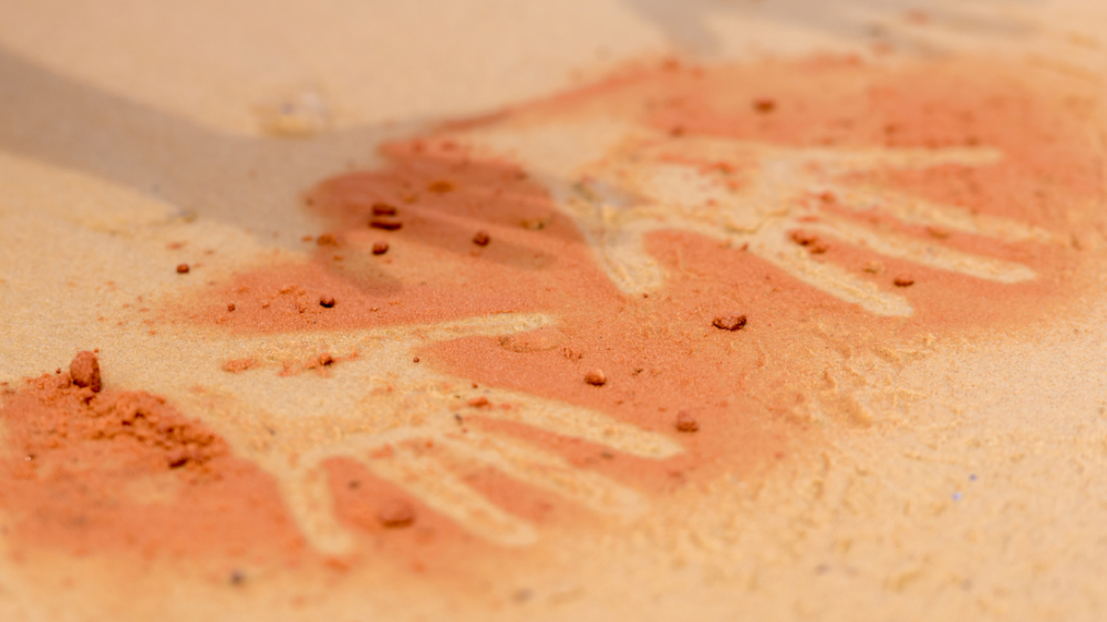 Hand prints on desert sand