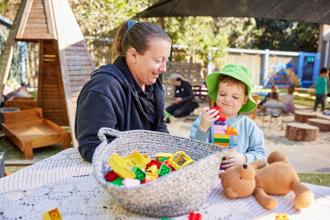 Boy playing with blocks with educator