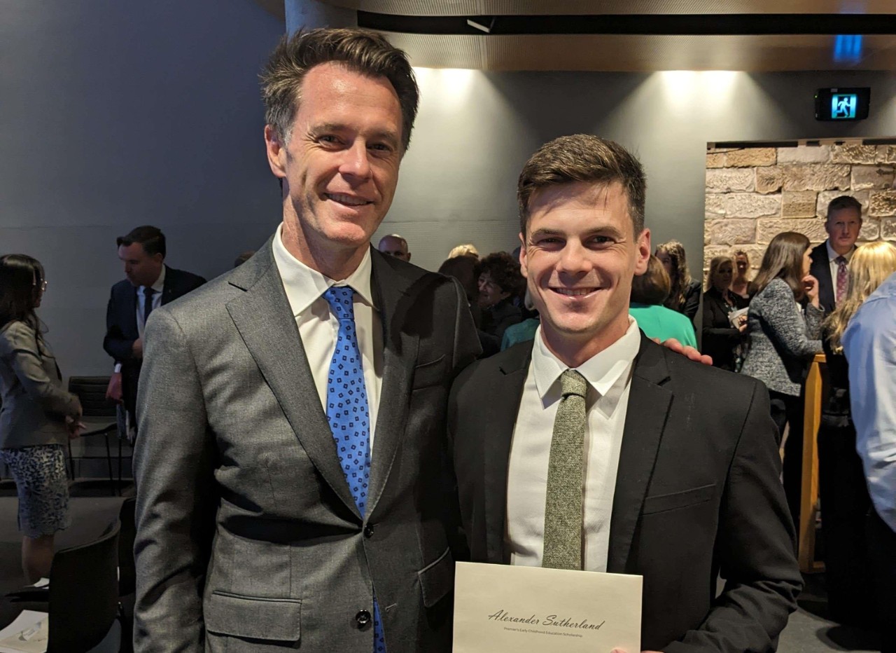 Alex Sutherland poses with Premier Chris Minns holding his scholarship award.