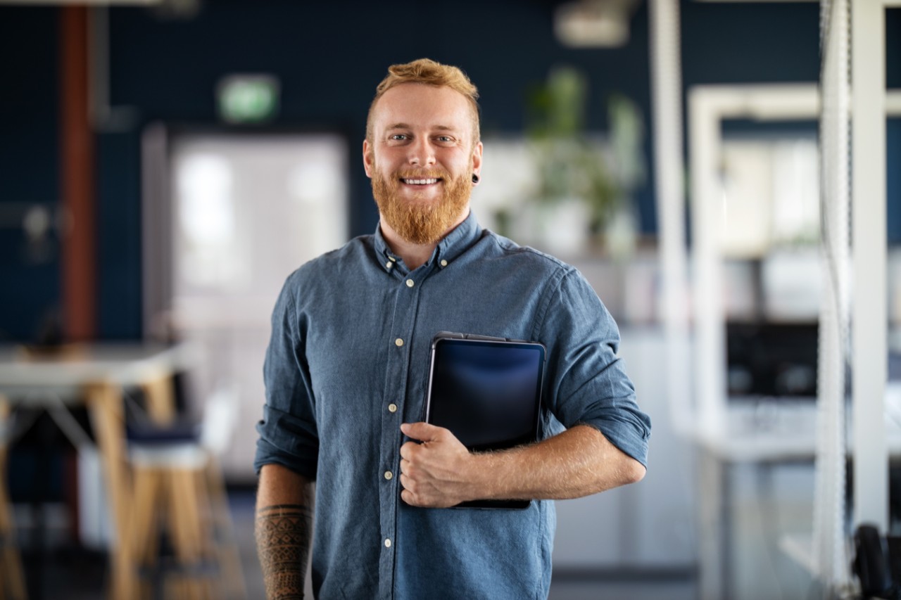 Man standing in office holding folio