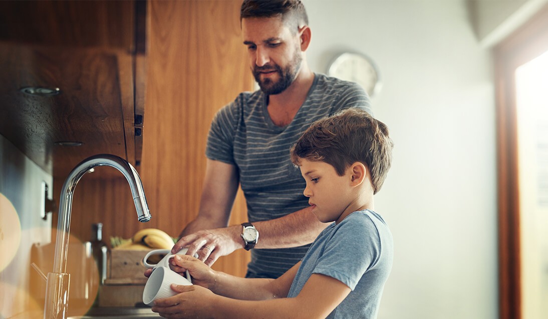 Father helping son to wash his hands