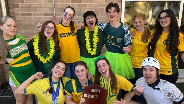 A Group of students dressed in fancy dress featuring green and gold