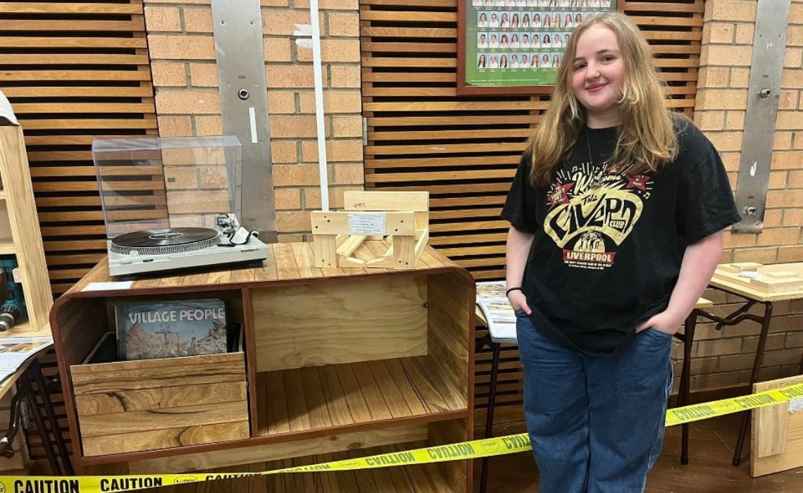 A girl standing in front of a cabinet.