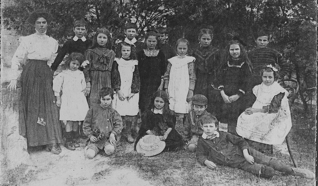 Black and white photo of children and adult.