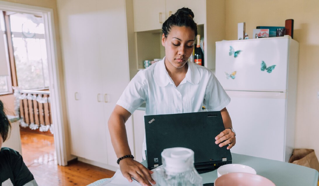 A HSC student uses a laptop in her family kitchen