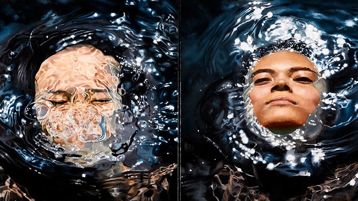 Two faces with one underwater and one emerging out of the water