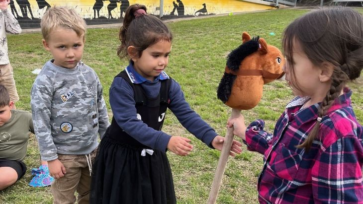 Students with a toy horse.