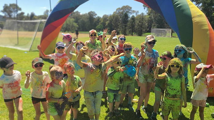 A group of children covered in colours after completing a colour run