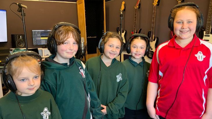 Five children wearing headphones.