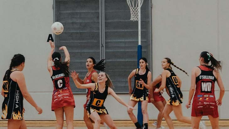 Two teams on a netball court.