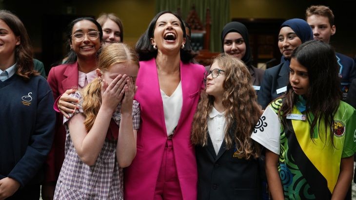 A woman laughing with students.