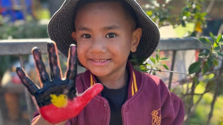 A student with the Aboriginal flag painted on their hand.