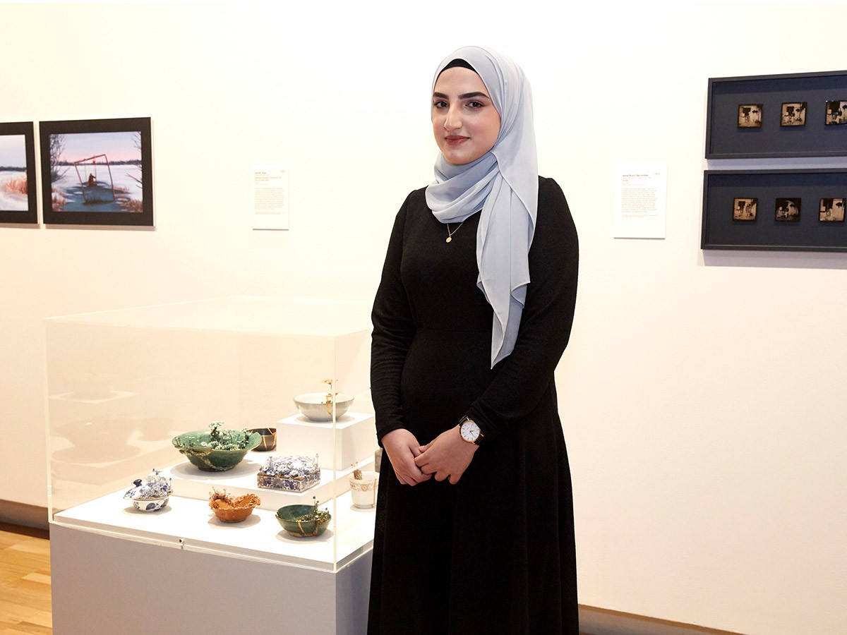 Lemah Orya in front of her artwork