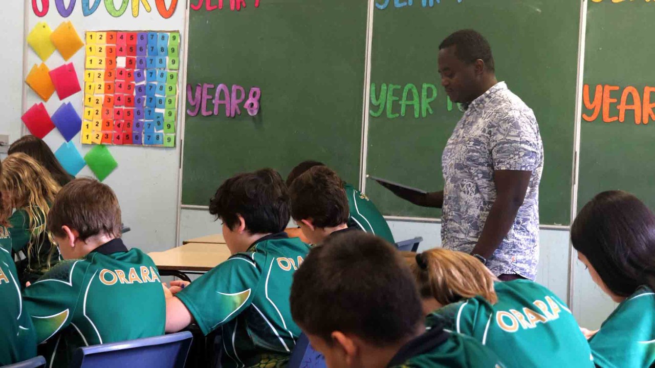 Refugee teacher teaching in his classroom