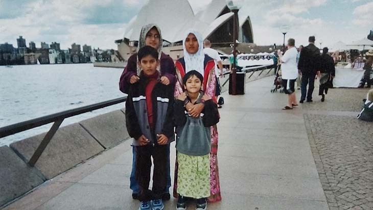 A family standing in front of the Sydney Opera House.