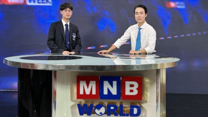 Two people standing at a desk.