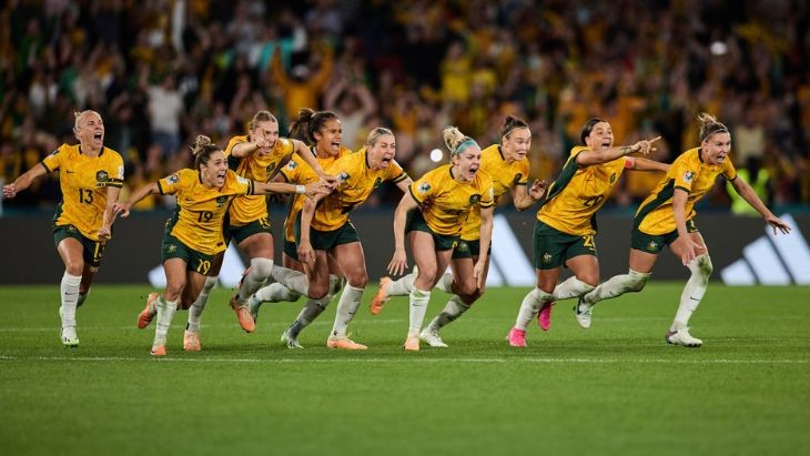 Female soccer players celebrating on the field.