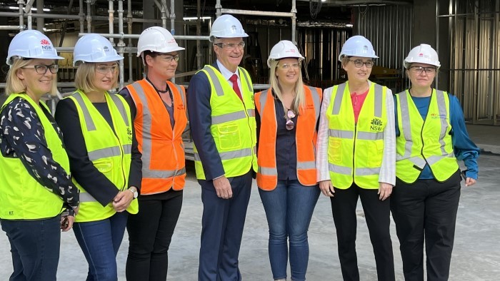 A group of six women and one man wearing hardhats