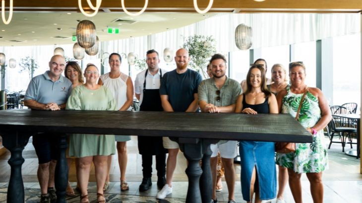 People standing behind a table in a restaurant.
