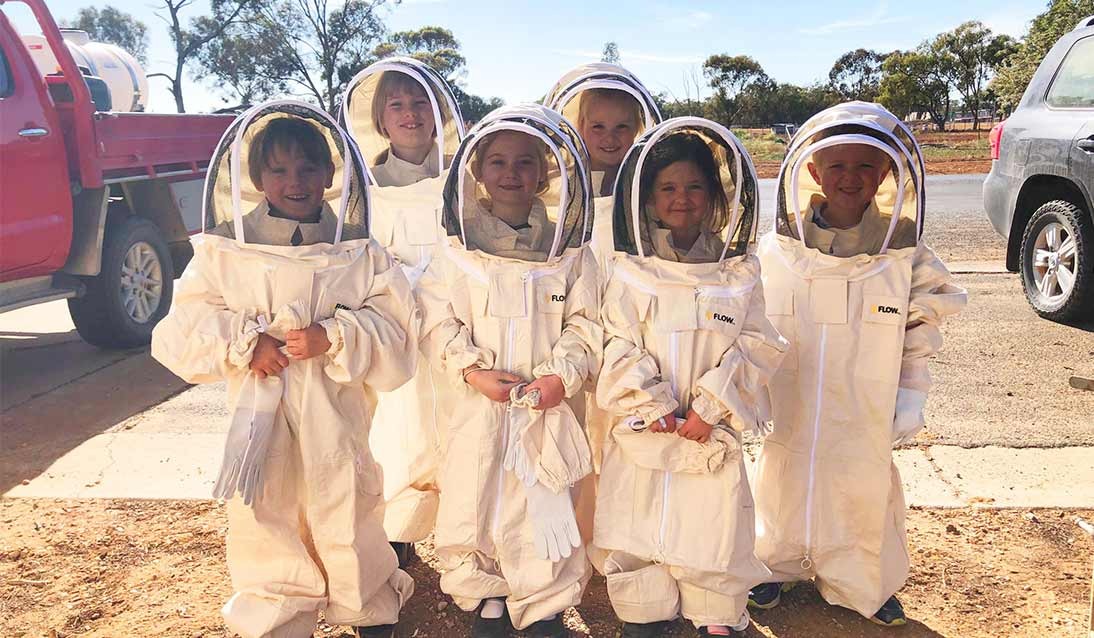 Students wearing beekeeping suits.