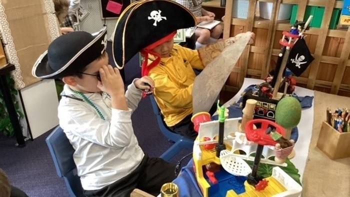 Two boys dressed as pirates playing in classroom