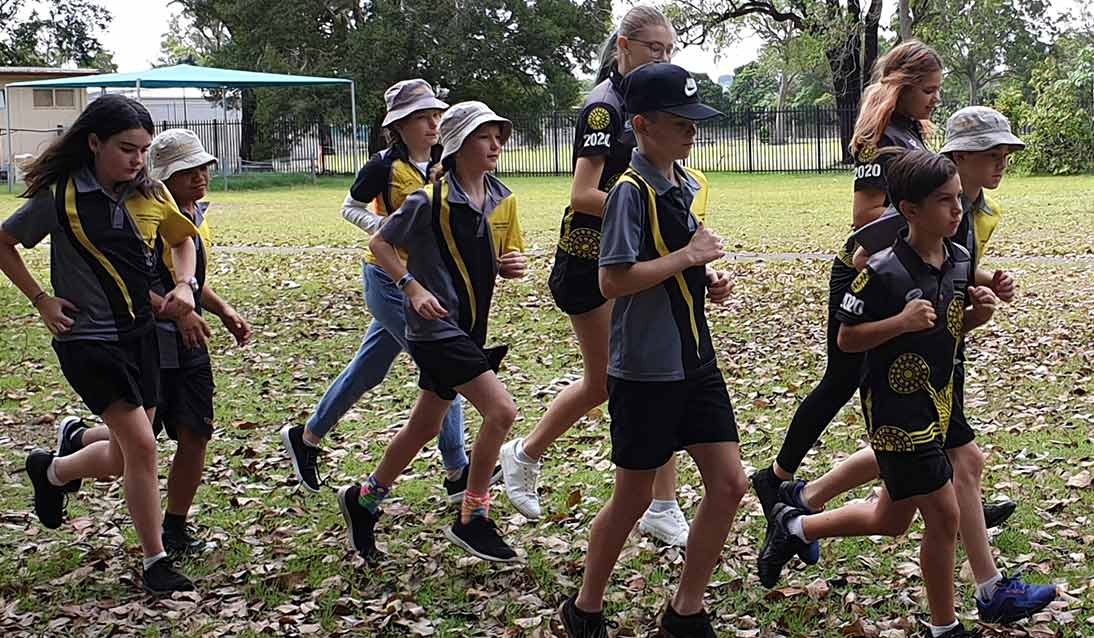A group of nine students is running around a park