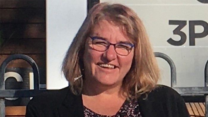 A headshot of a woman wearing glasses