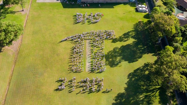 An aerial shot of students making the symbol for Pi.