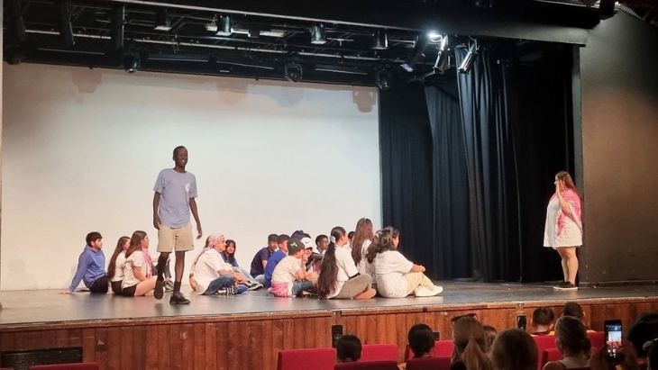 Students standing and sitting on stage.