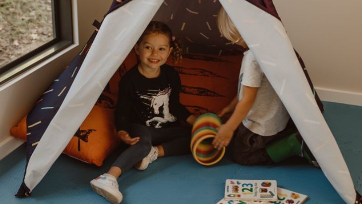 Two students inside a teepee.