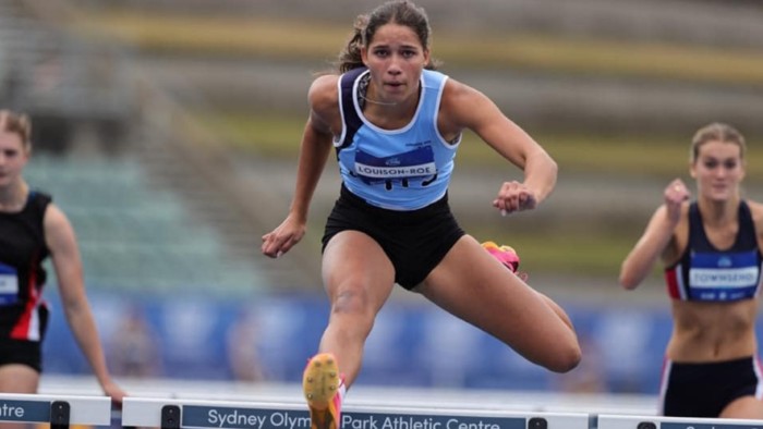 A young woman doing hurdles