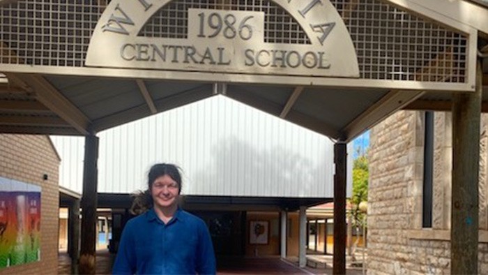 A man standing in front of a school entrance
