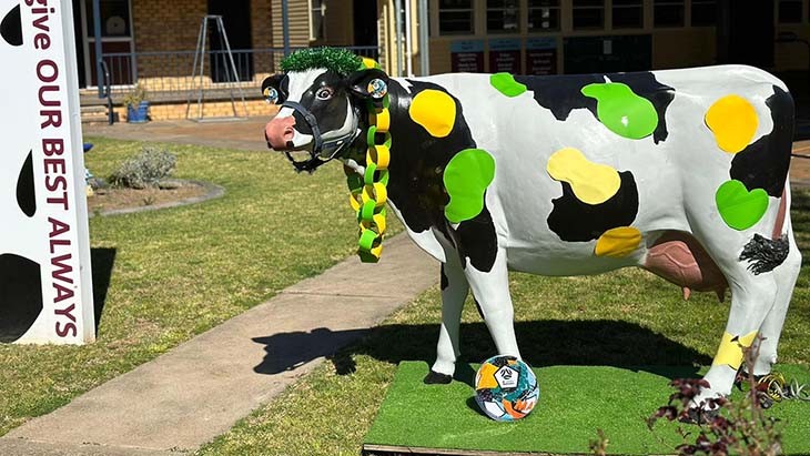 A cow with green and gold spots.
