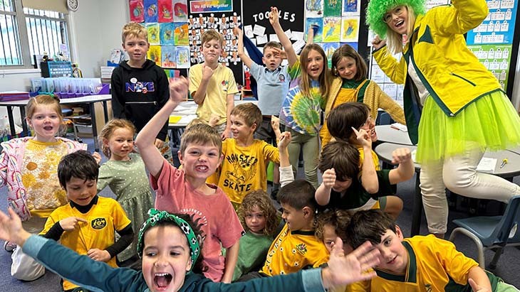 Students and a teacher dressed in green and gold.