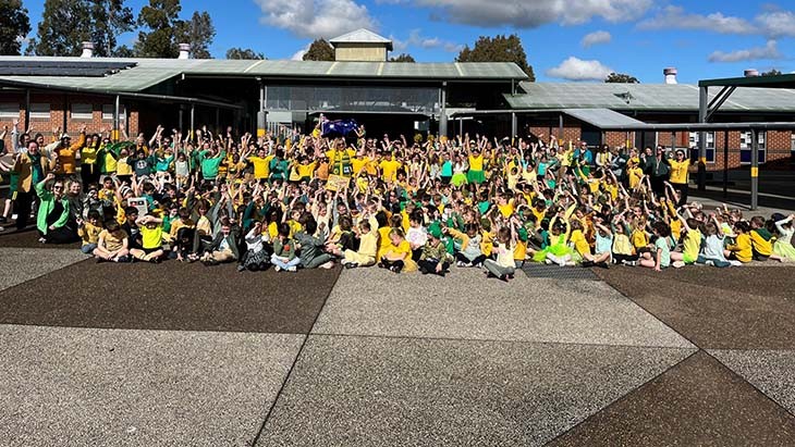 Students and staff wearing green and gold.