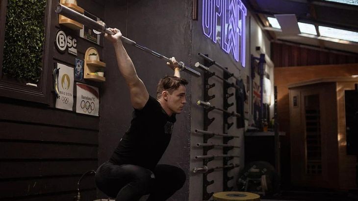 A man lifting a weights bar.
