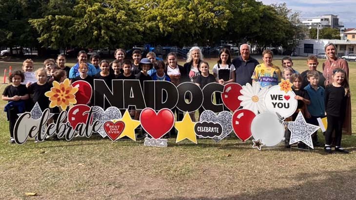 Students, Elders and staff with a NAIDOC sign.