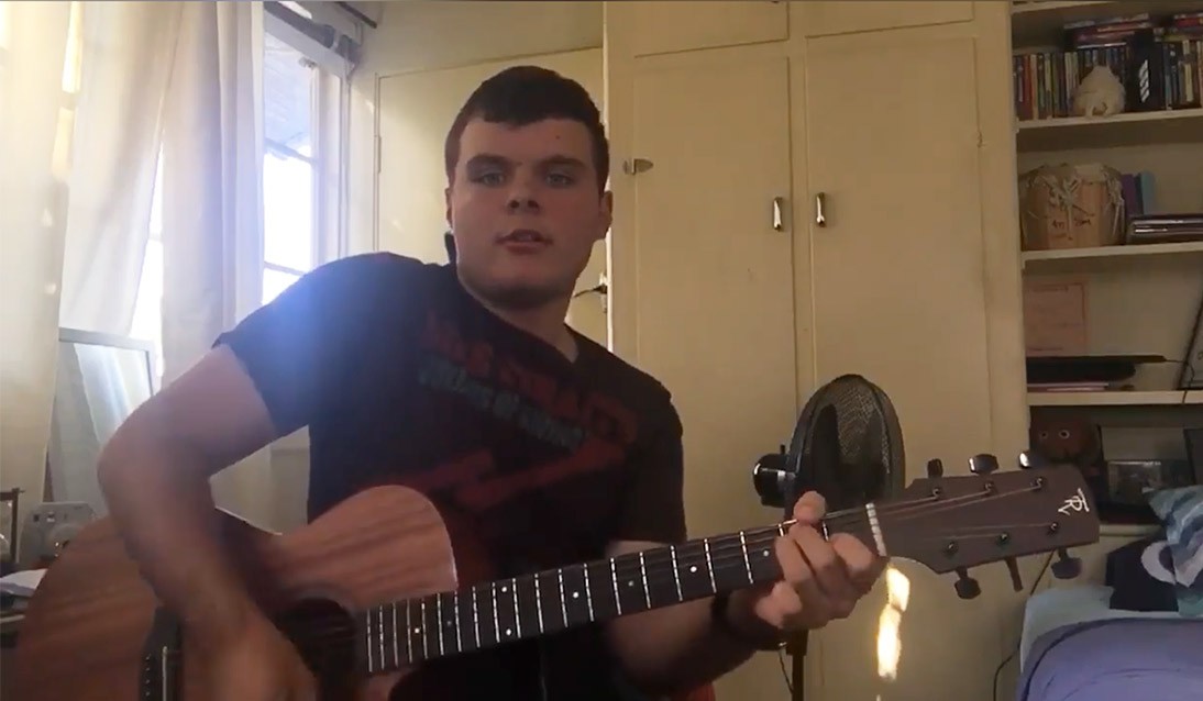 A teenage boy playing the guitar.