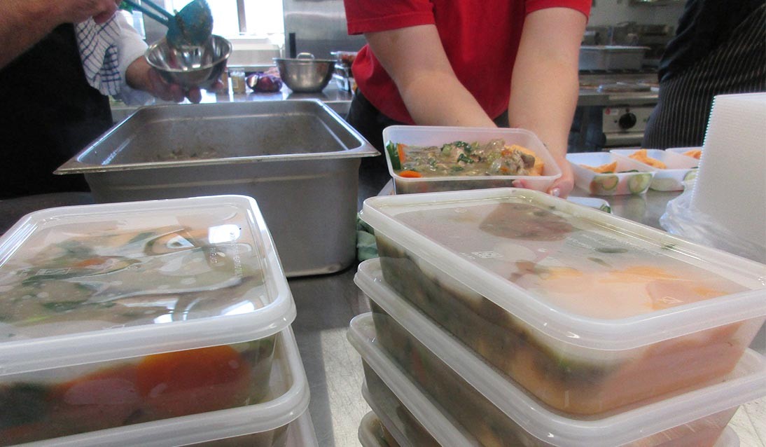 Plastic takeaway containers full of food.