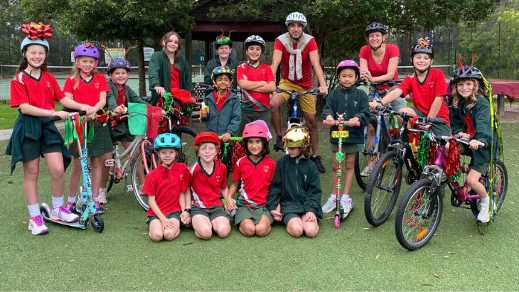 Students and teachers with bikes and scooters.