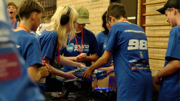 Students surrounding a remote-controlled car.