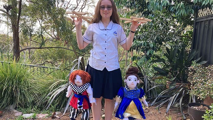 A girl holding a puppet in each hand